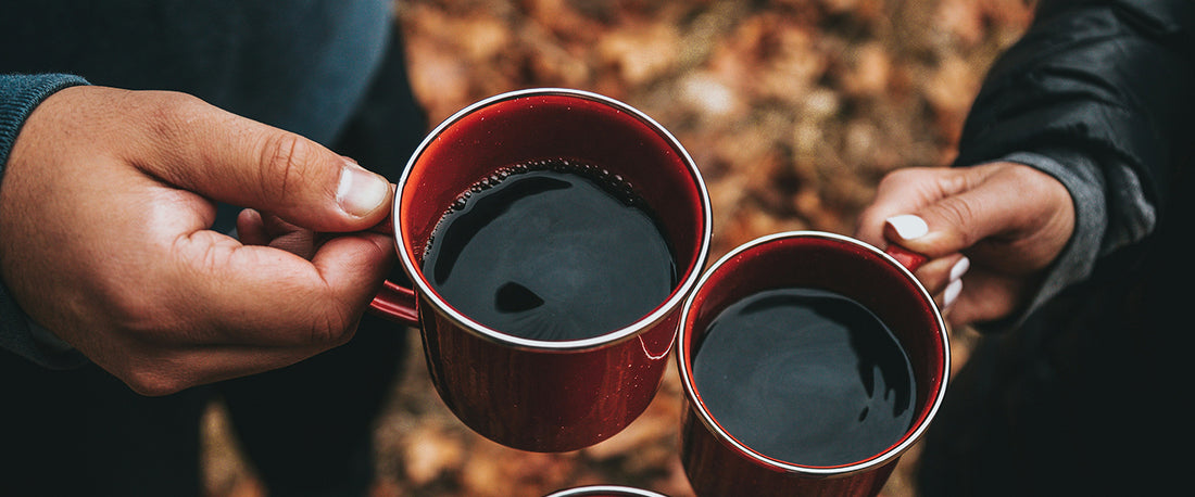 Two people drinking coffee during the fall.