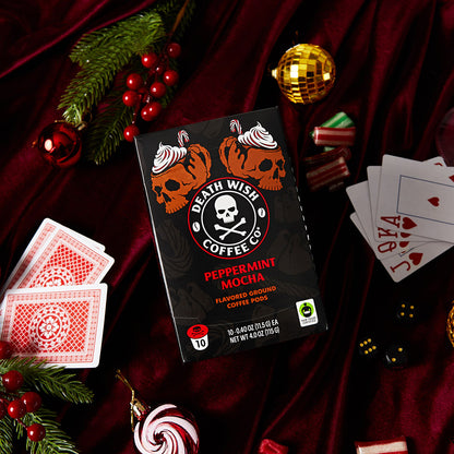 A box of Peppermint Mocha flavored Death Wish Coffee Single-Serve Pods surrounded by holiday inspired accents and accessories.