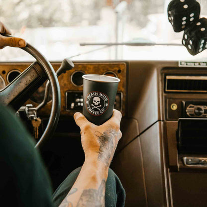 Drinking Death Wish Coffee with Fuzzy Dice Danglers hanging from the mirror.