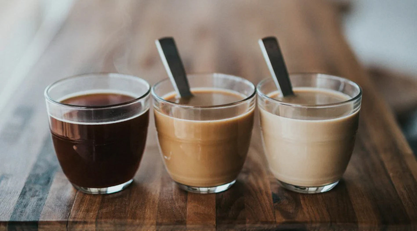 A lineup of coffee with different creamer levels. [Image Source: Nathan Dumlao via Unsplash]